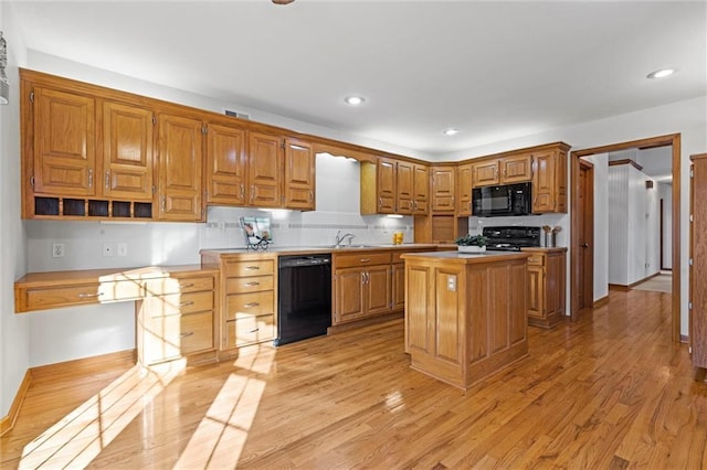 kitchen with a center island, light hardwood / wood-style flooring, backsplash, and black appliances