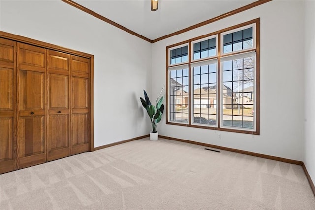 unfurnished bedroom featuring crown molding, ceiling fan, and light carpet