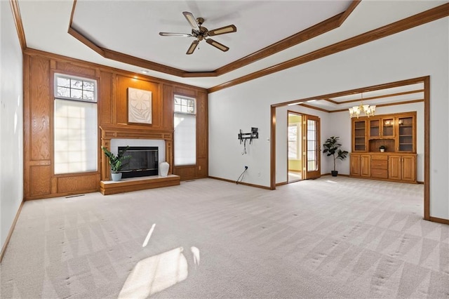 unfurnished living room with crown molding, light carpet, a fireplace, and a tray ceiling