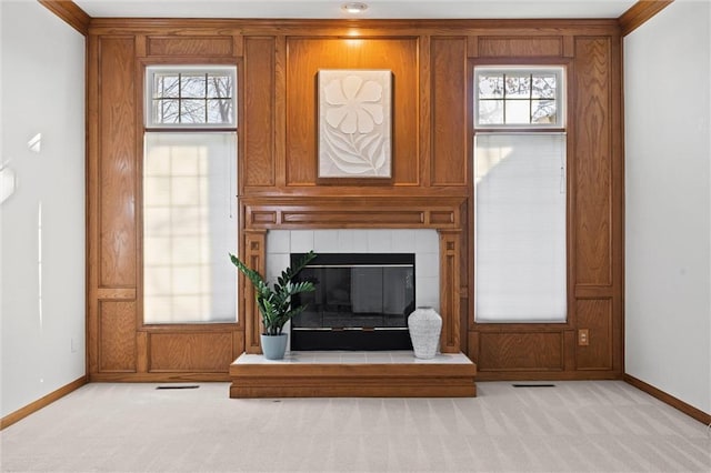 unfurnished living room featuring light carpet, a fireplace, and a wealth of natural light