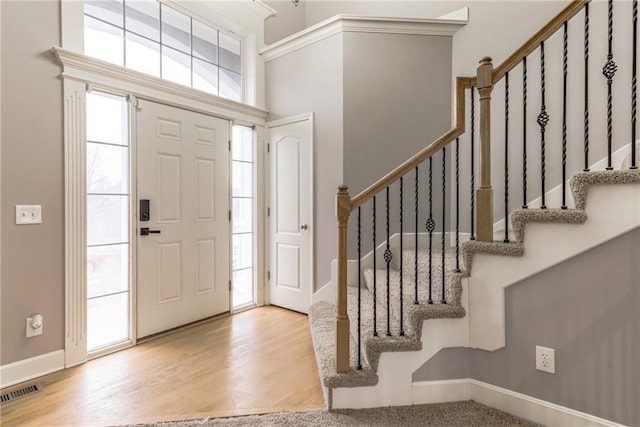 foyer with a high ceiling and light hardwood / wood-style flooring