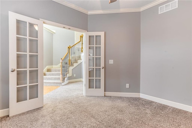 carpeted spare room with ornamental molding and french doors