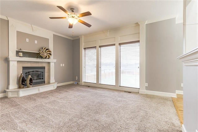 unfurnished living room featuring carpet floors, ornamental molding, a tile fireplace, and ceiling fan