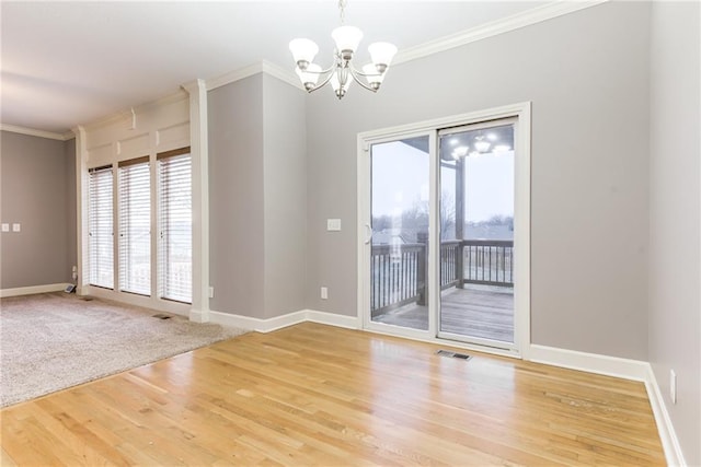 empty room with an inviting chandelier, ornamental molding, and hardwood / wood-style floors