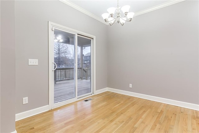 empty room with crown molding, hardwood / wood-style floors, and a notable chandelier