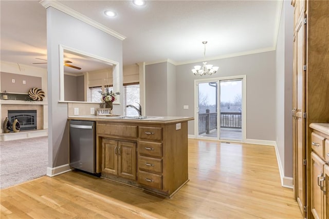 kitchen with ceiling fan with notable chandelier, pendant lighting, dishwasher, sink, and crown molding