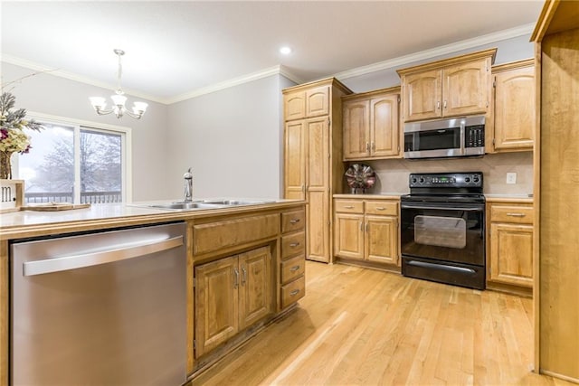 kitchen with sink, appliances with stainless steel finishes, hanging light fixtures, ornamental molding, and light hardwood / wood-style floors