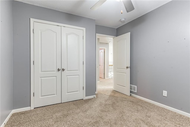 unfurnished bedroom with ceiling fan, light colored carpet, and a closet