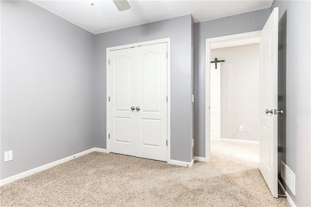 unfurnished bedroom featuring light carpet, a closet, and ceiling fan