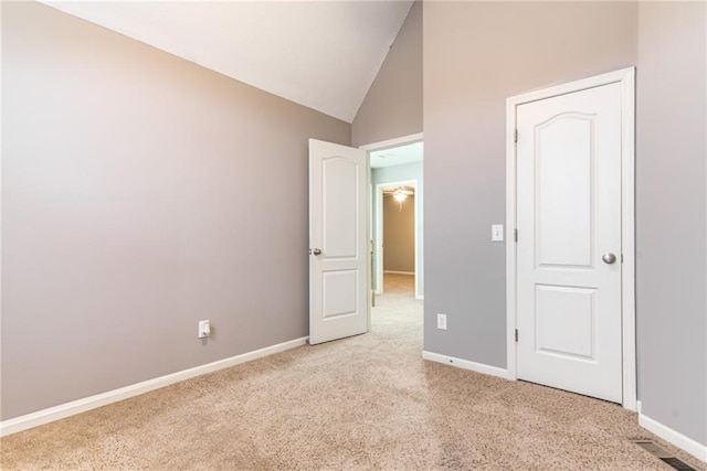 unfurnished bedroom featuring light colored carpet and high vaulted ceiling