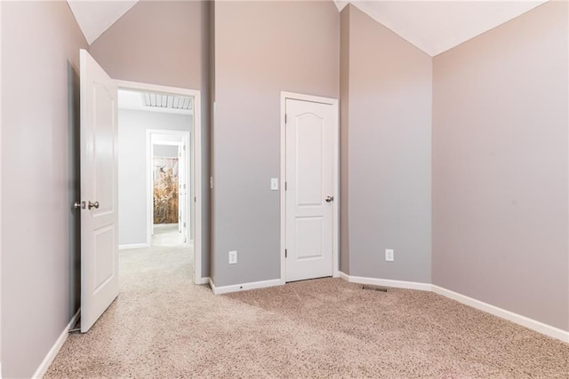 unfurnished bedroom featuring carpet flooring and vaulted ceiling