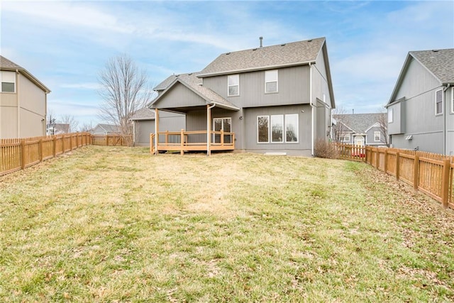 rear view of house with a wooden deck and a yard