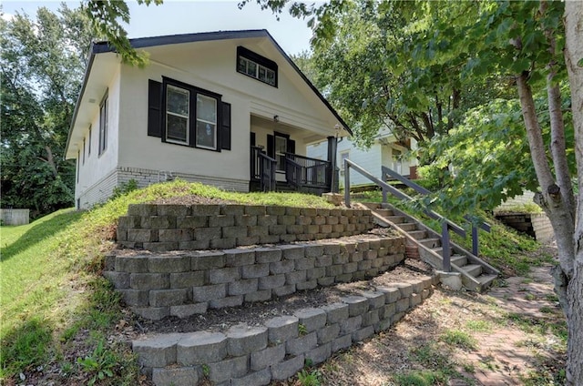 back of property featuring covered porch