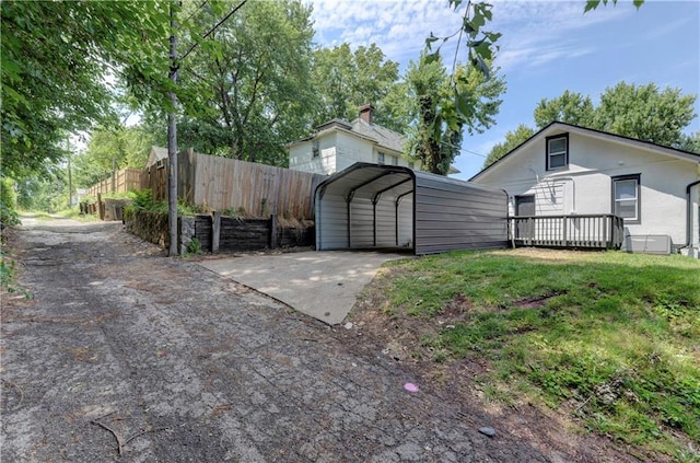 view of side of property with a carport and a wooden deck