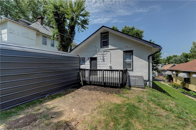 back of house with a lawn and a deck