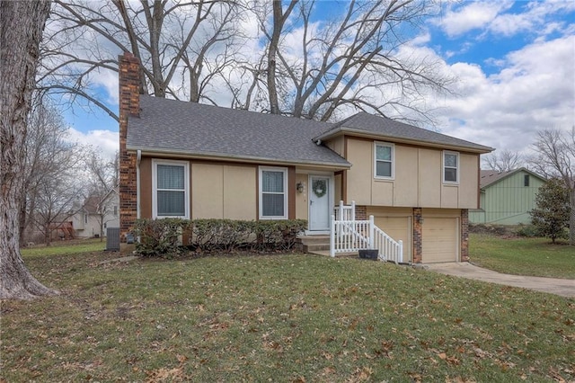 tri-level home with a garage, a front yard, and central air condition unit