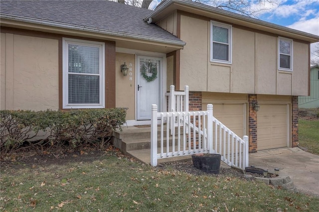 entrance to property featuring a garage and a yard