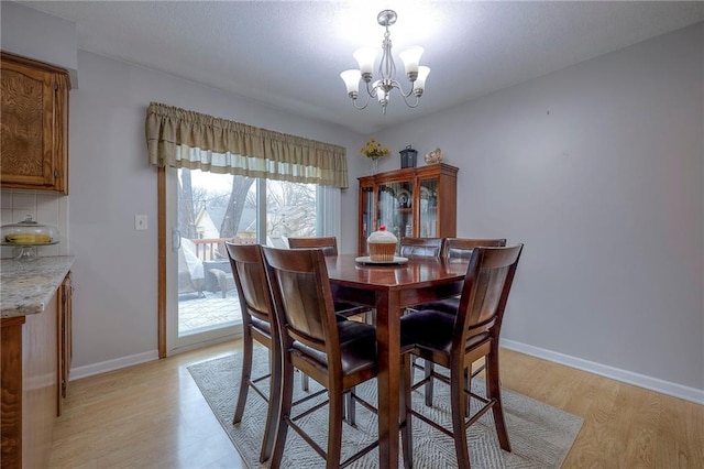 dining area featuring light hardwood / wood-style flooring and a notable chandelier