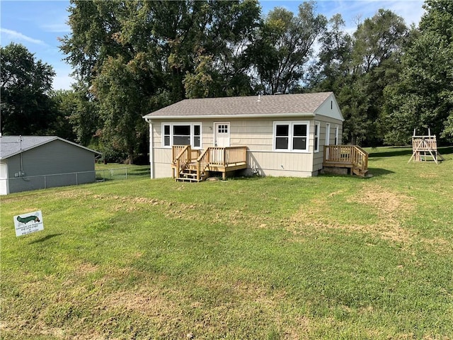 back of property featuring fence and a yard