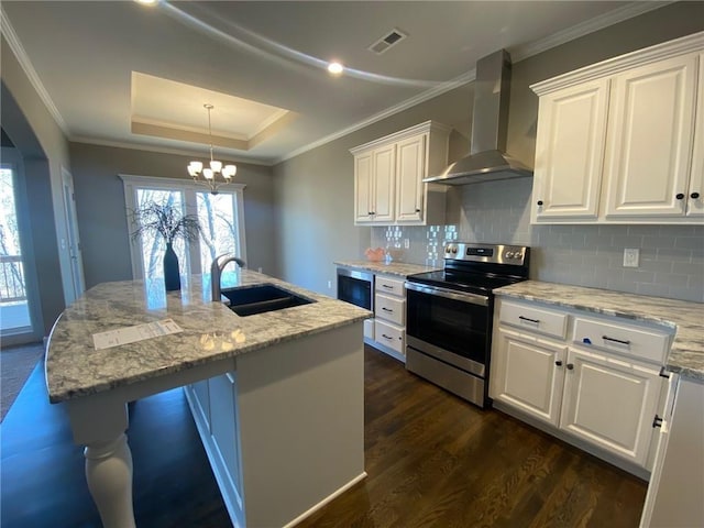 kitchen featuring white cabinets, a raised ceiling, stainless steel electric range, wall chimney range hood, and a sink