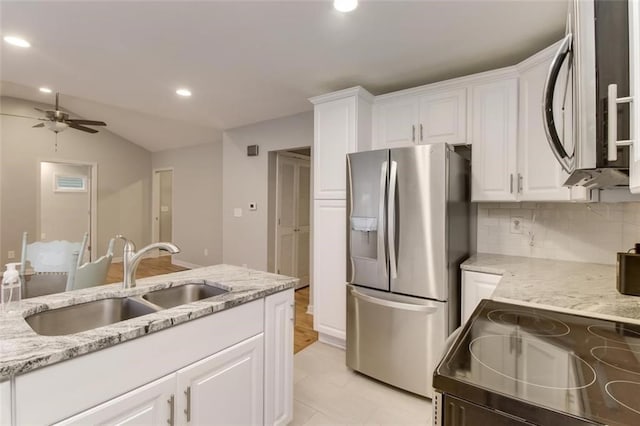 kitchen with white cabinetry, sink, decorative backsplash, light stone counters, and stainless steel appliances