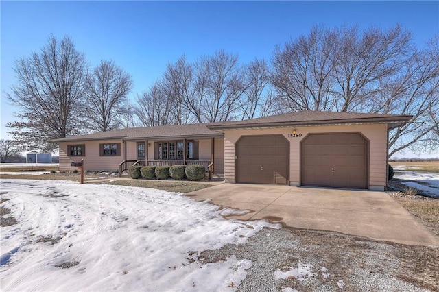 ranch-style home featuring a garage and covered porch