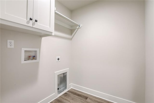 clothes washing area featuring hookup for an electric dryer, cabinets, washer hookup, and light hardwood / wood-style flooring