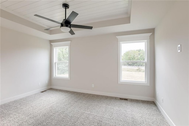 carpeted spare room with ceiling fan and wooden ceiling