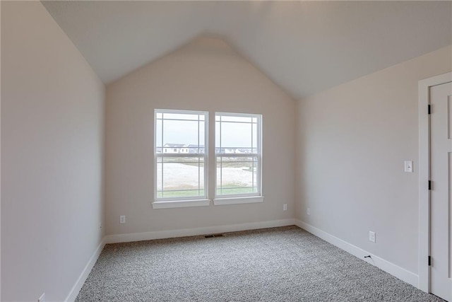 empty room featuring carpet floors and lofted ceiling