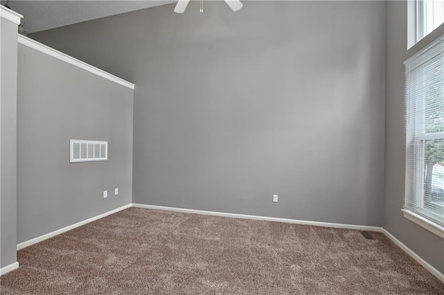 empty room featuring a healthy amount of sunlight, carpet floors, baseboards, and visible vents