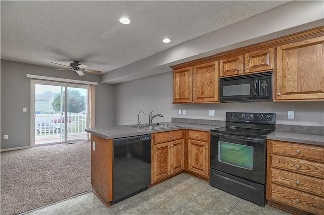 kitchen featuring light colored carpet, brown cabinetry, a sink, a peninsula, and black appliances