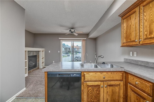 kitchen featuring brown cabinetry, dishwasher, a peninsula, light countertops, and a sink