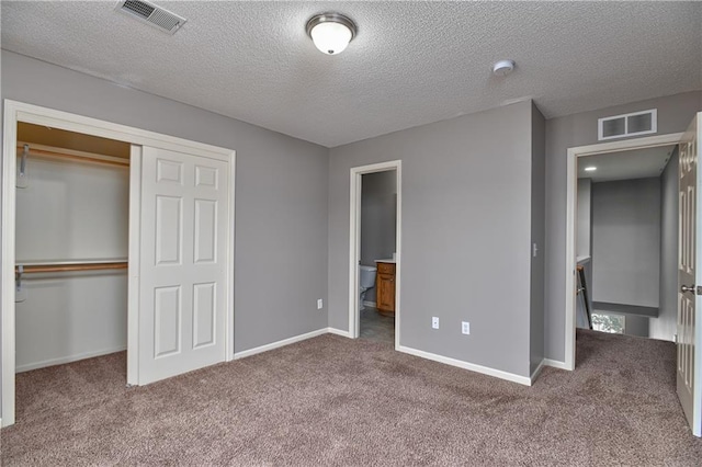 unfurnished bedroom with carpet floors, visible vents, and a closet