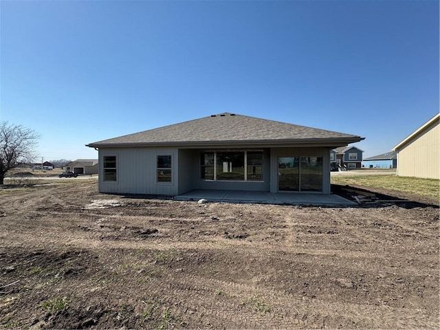 rear view of property with a patio and roof with shingles