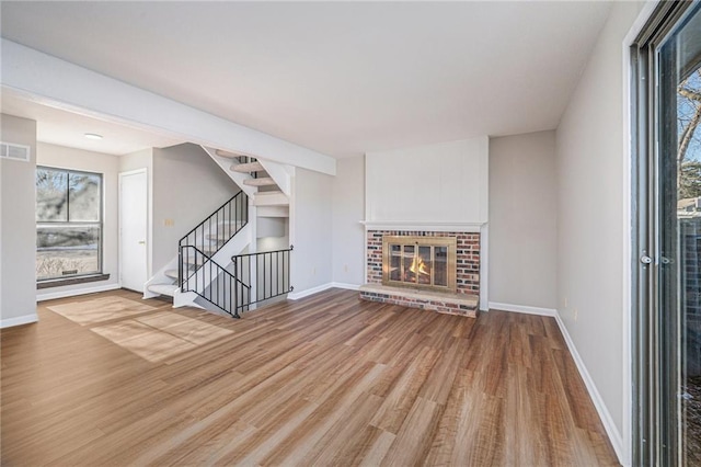 unfurnished living room with wood-type flooring and a fireplace