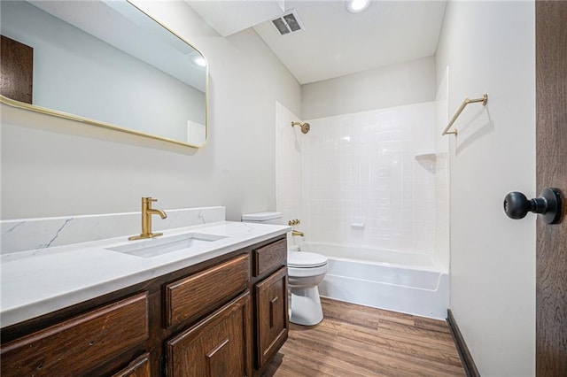 full bathroom featuring hardwood / wood-style flooring, tiled shower / bath combo, vanity, and toilet