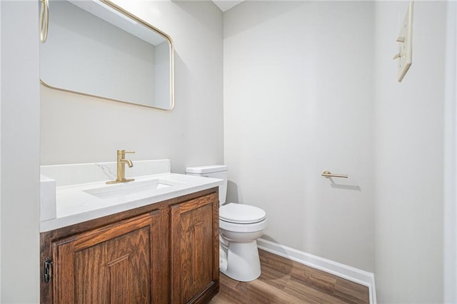 bathroom with vanity, toilet, and hardwood / wood-style flooring