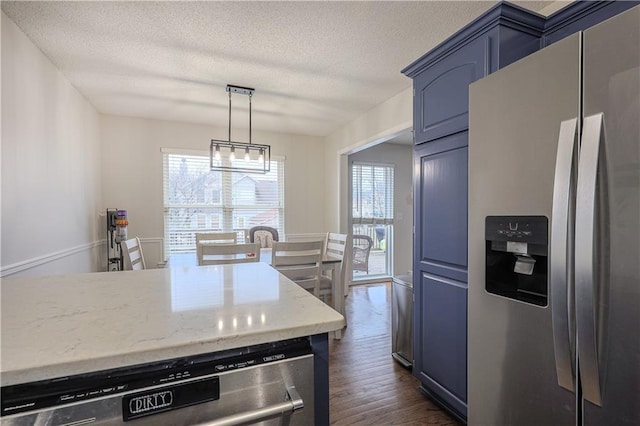 kitchen featuring blue cabinetry, pendant lighting, a textured ceiling, dark hardwood / wood-style floors, and stainless steel appliances