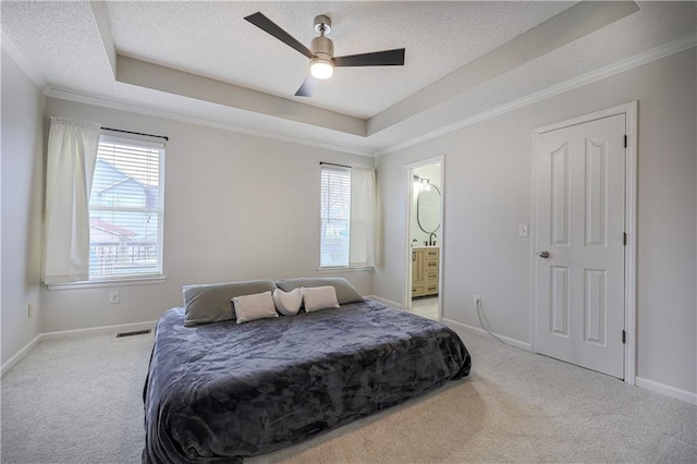 bedroom with multiple windows, light carpet, and a raised ceiling