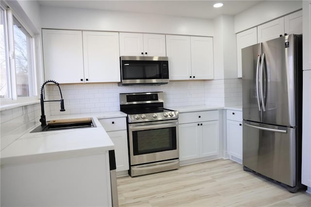 kitchen with white cabinetry, appliances with stainless steel finishes, and sink