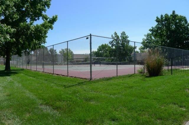 view of sport court with a lawn