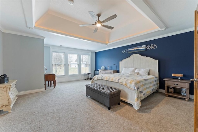 carpeted bedroom with ceiling fan, ornamental molding, and a tray ceiling