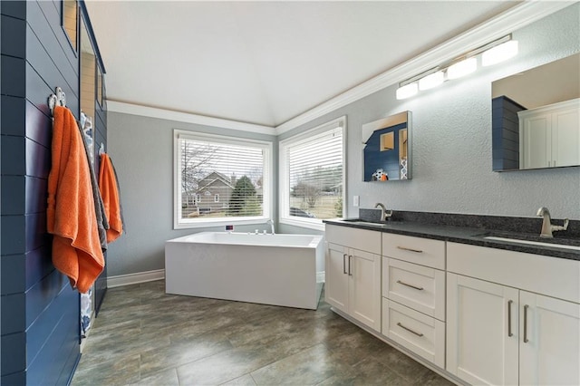 bathroom with vanity, a washtub, and lofted ceiling