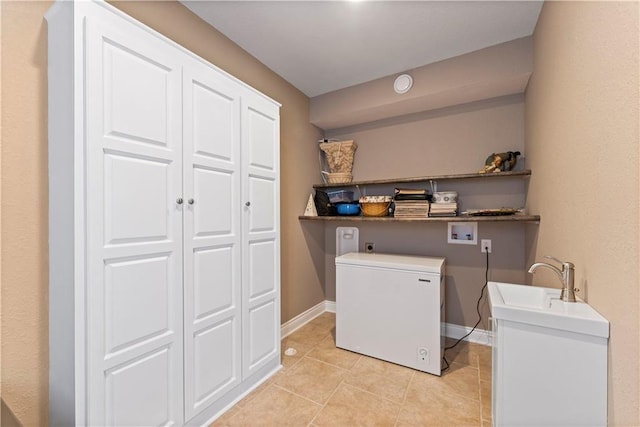 washroom with washer hookup, hookup for an electric dryer, and light tile patterned floors