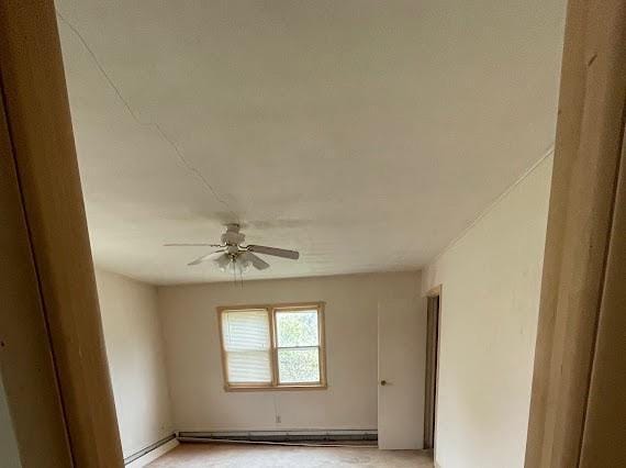 empty room featuring baseboard heating and ceiling fan