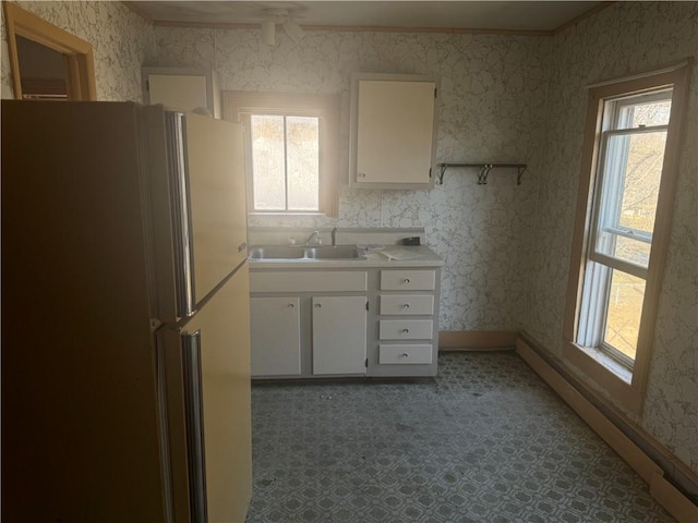 kitchen with sink, white cabinets, and refrigerator