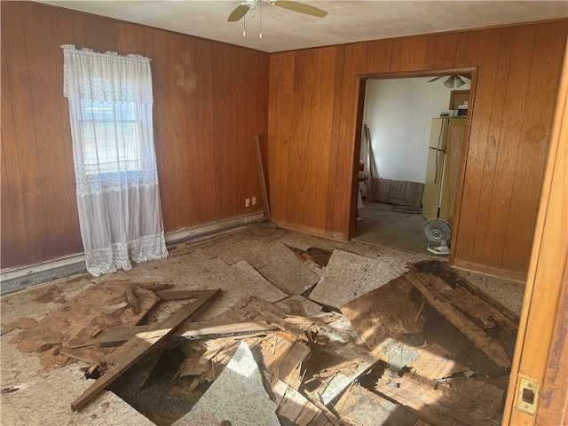 empty room featuring wood walls and ceiling fan