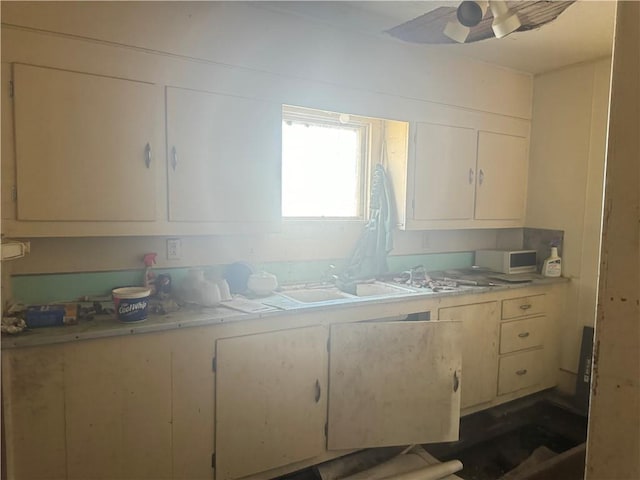 kitchen featuring ceiling fan and sink