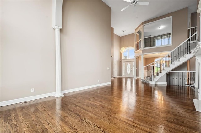 4749 SW Gull Point Dr, Lees Summit, MO 64082 - unfurnished living room with ornate columns, a high ceiling, ceiling fan, stairs, and wood finished floors