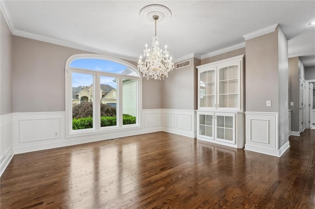 4749 SW Gull Point Dr, Lees Summit, MO 64082 - unfurnished dining area featuring a chandelier, a wainscoted wall, wood finished floors, ornamental molding, and a decorative wall